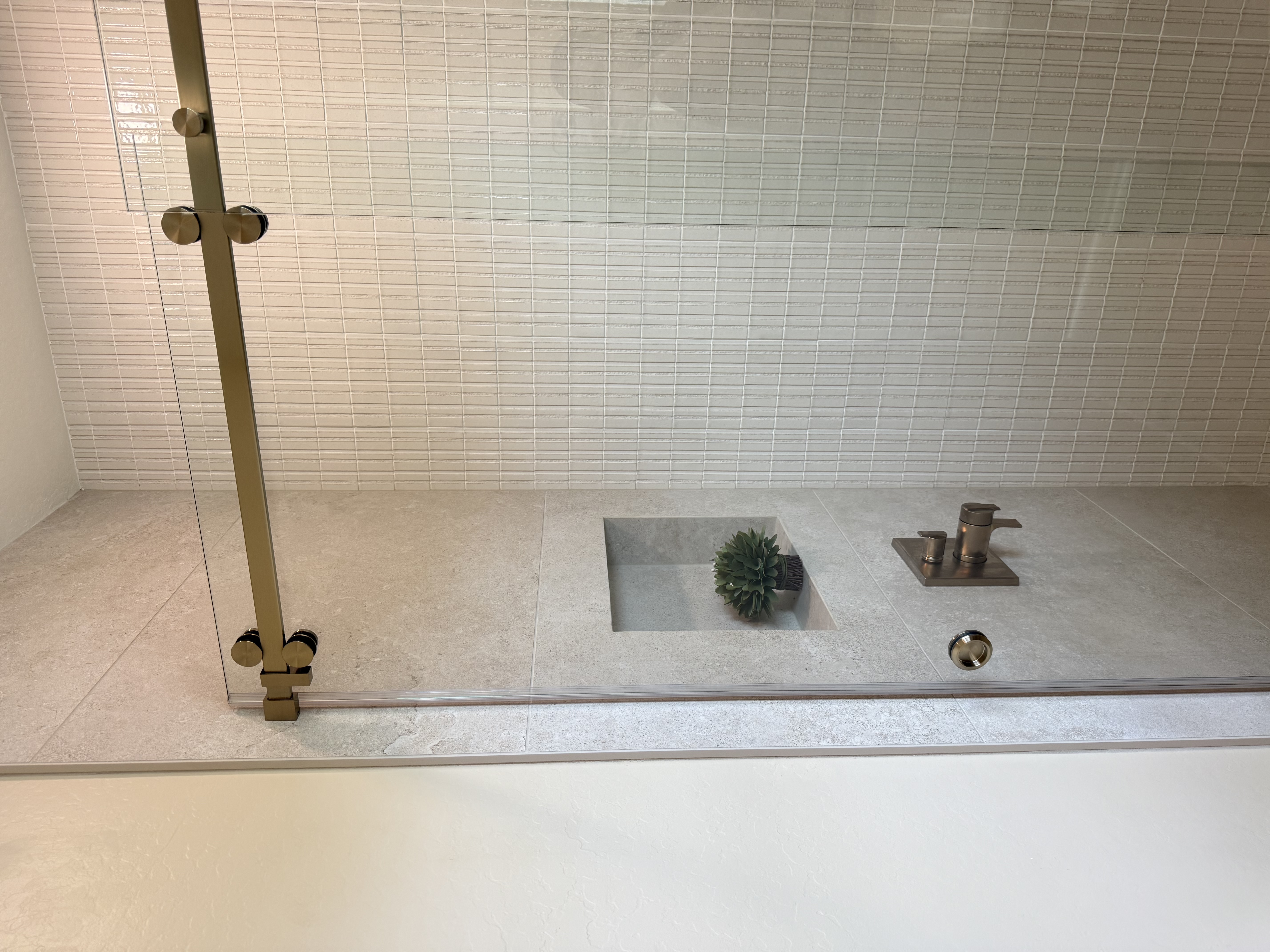 Shower floor with linear drain and gold hardware by Level Up Tile
