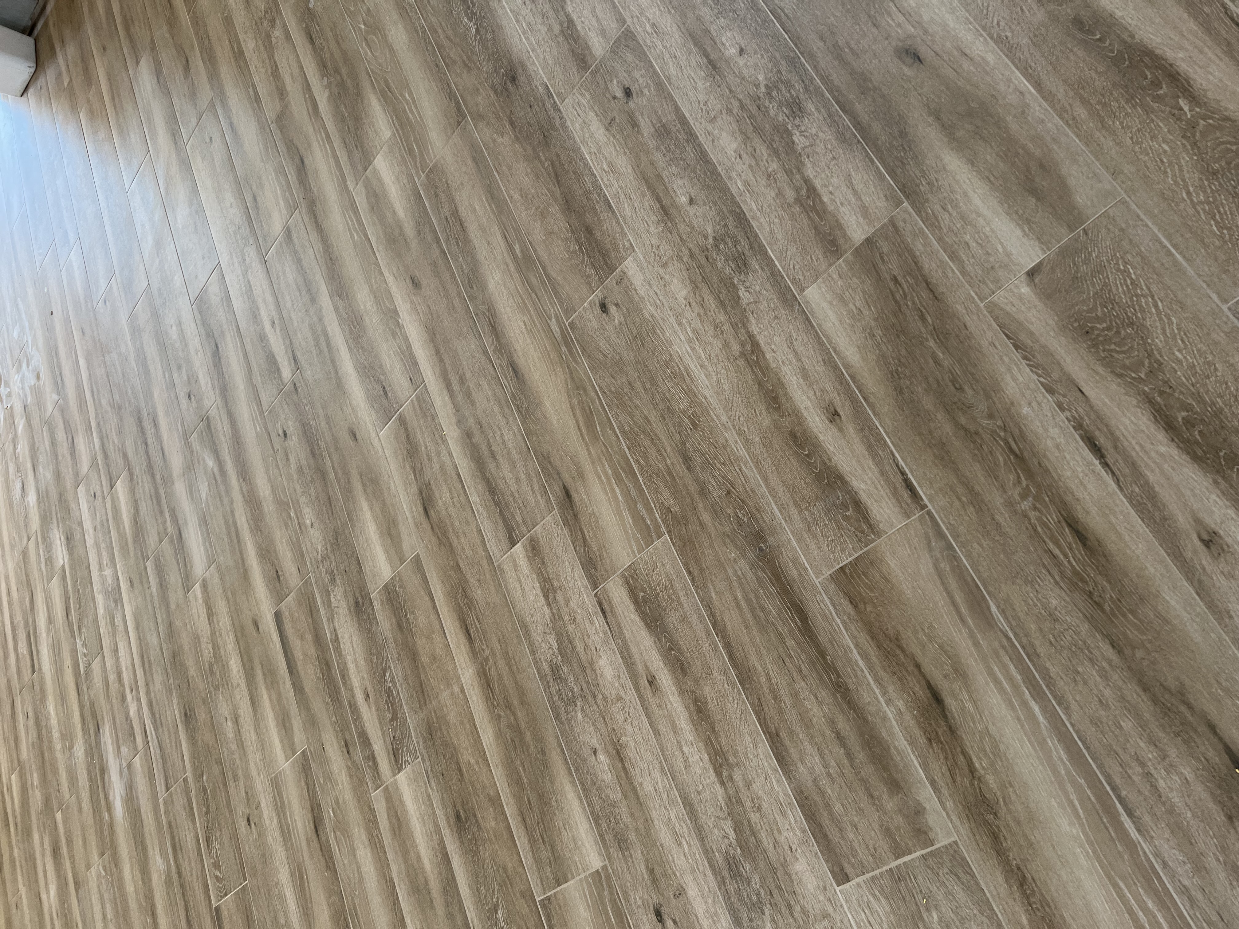 Wood-look plank tile close-up showing precision grout joints by Level Up Tile