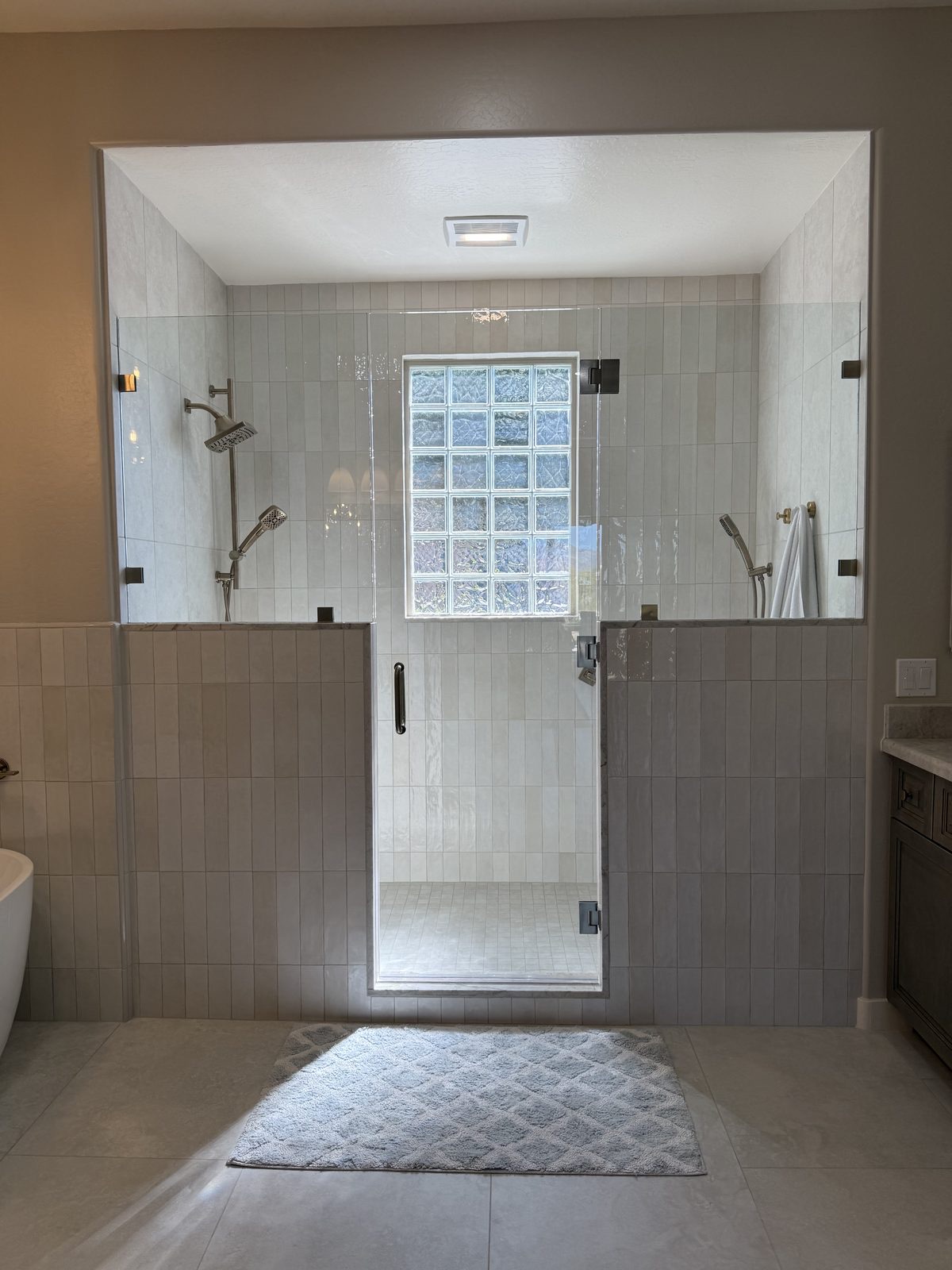 Frameless glass shower enclosure with matte black hardware by Level Up Tile in Peoria AZ