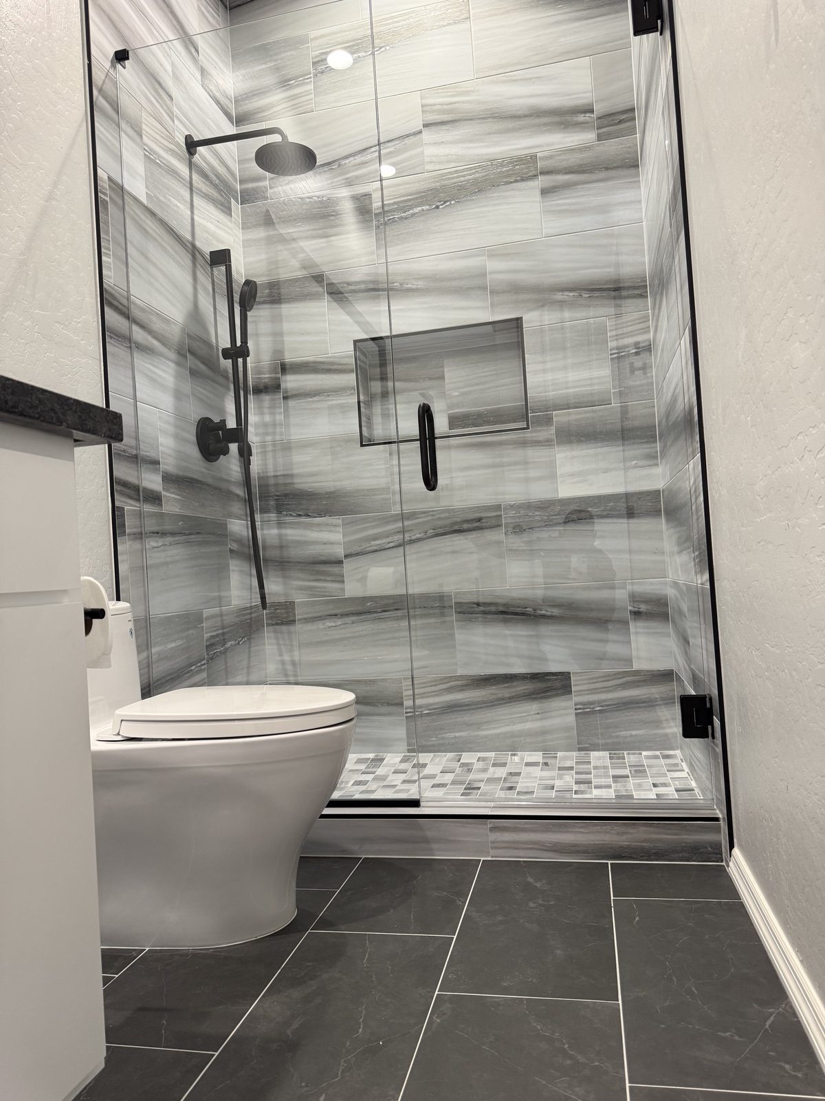 Semi-frameless glass shower enclosure by Level Up Tile