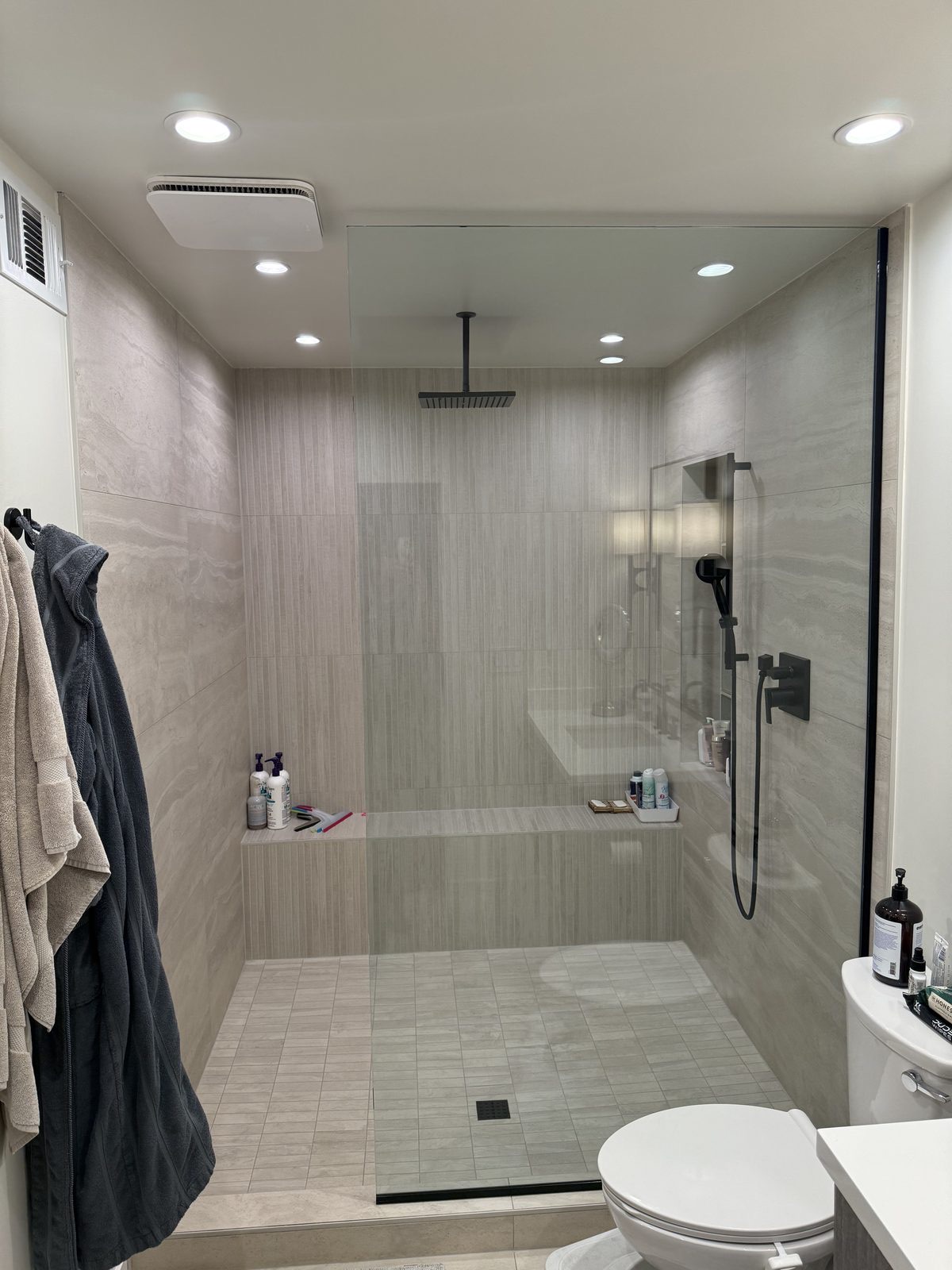 Walk-in curbless shower with fixed glass panel by Level Up Tile in Scottsdale AZ