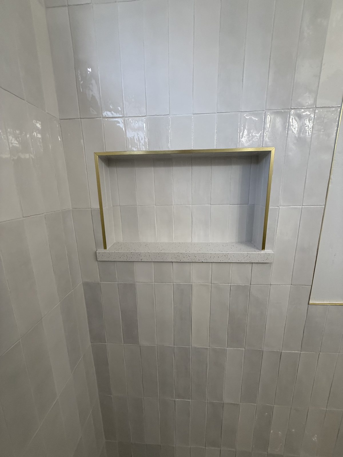 Luxury glass shower enclosure with gold fixtures and polished porcelain in Peoria AZ