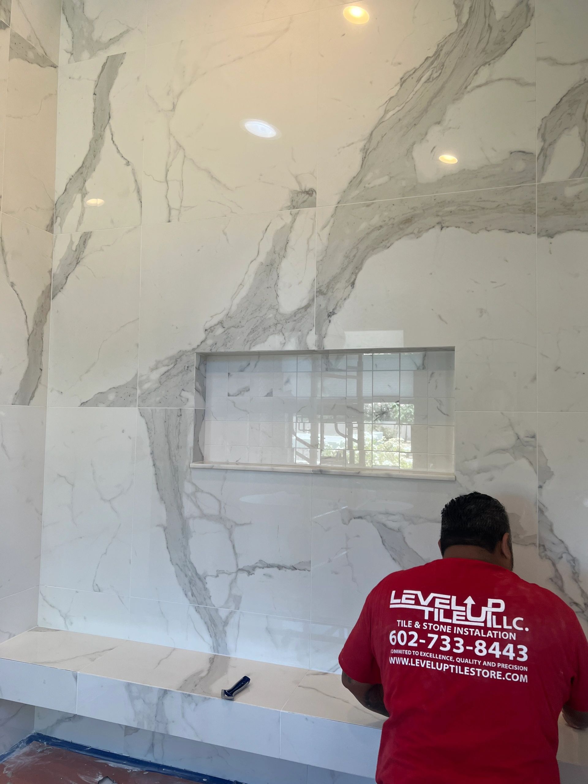 Level Up Tile installer working on custom marble shower with Schluter Kerdi waterproofing in Scottsdale AZ